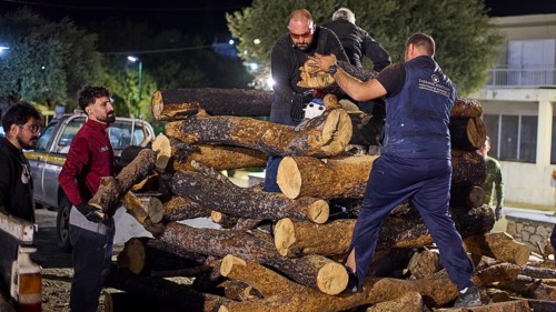 ©Udo Rein, Men stacking large logs together in an urban environment, Easter bonfire Psinthos, Holy