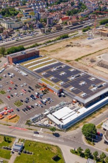Aerial view of buildings with solar cells surrounded by an urban landscape, PV system at OBI