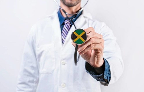 Jamaica healthcare system, doctor holding stethoscope. Jamaica health and medical insurance concept
