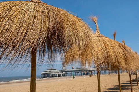 A row of raffia parasols on the beach at Scheveningen in the Netherlands