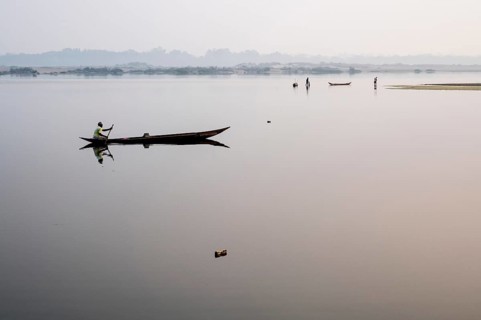 Man boating on the Mahanadi river (Odisha, India), two fishermen in the background