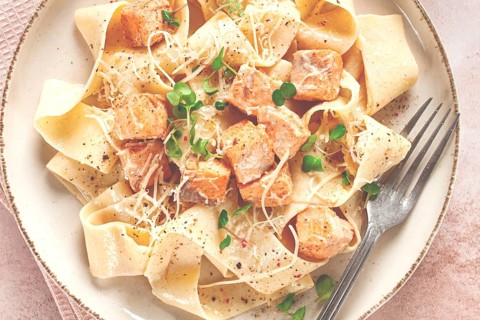 Tagliatelli pasta, with salmon slices and herbs, on a decorative plate, homemade, no people