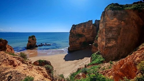 Praia Dona Ana, a picturesque coastal landscape with large rocks, calm sea and sandy beach under