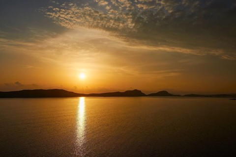 A calm sunset over the sea with light clouds in the sky, Navarino Bay, Pylos, Peloponnese, Greece