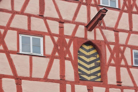 Red half-timbered house with beams and pulley as crane and elevator, window, gate, Herrngasse,