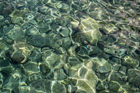 Clear water surface with shimmering stones and light reflections, Stromboli, Aeolian or Lipari