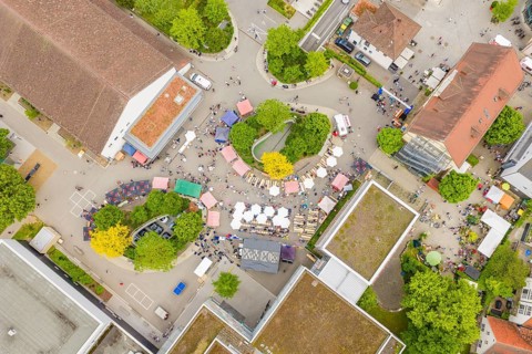 Bird's eye view of a lively market with lots of people and stands, European market and garden fair,