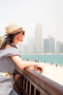 Close up portrait happy young woman wear dress and straw hat visiting UAE capital Au Dhabi relax