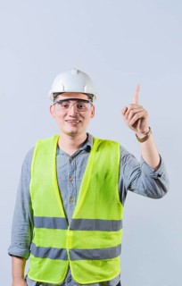 Latin engineer pointing up isolated. Smiling engineer pointing at an advertisement up