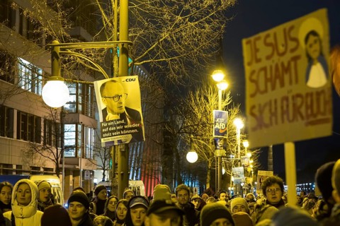 CDU and AfD election posters next to a sign Jesus is ashamed of you! at the demonstration under the