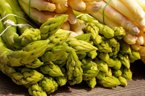 Green asparagus and white asparagus decorated on a rustic wooden table