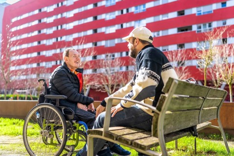 Two friends enjoying a sunny day in a vibrant urban park, sharing laughter and stories while