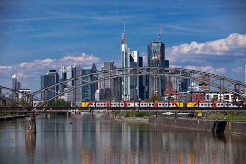 The river Main with regional railway on the Deutschherrnbrücke and the skyline of Frankfurt am