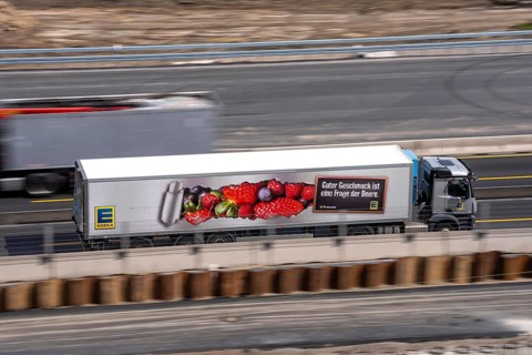Freight truck for food logistics, on the motorway, supermarket chain EDEKA