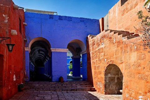 An architectural scene with eye-catching blue and red walls and elegant arches, The Santa Catalina