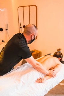 Home massage, performing a massage at the client's home, vertical photos. With a face mask in the