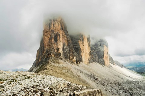 Dramatic misty Tre Cime di Lavaredo area. Dynamic clouds after rain move over the rugged limestone