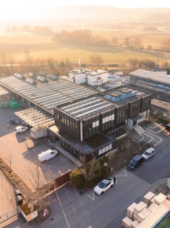 Industrial complex with solar cells, modern buildings in rural surroundings at morning light,