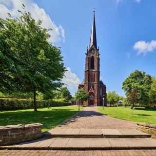 St. Nicholas parish church, church tower, sandstone wall, staircase, green area Bürgerpark, lawn,