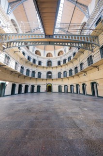 Expansive view of the ground floor of a round prison with multiple cells and doors, Kilmainham Gaol