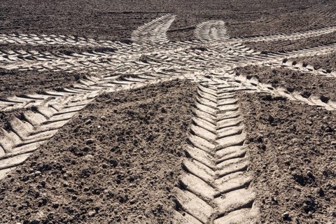 Tractor tracks, agricultural trails at a cultivated field in springtime, farmland near Wesertal,