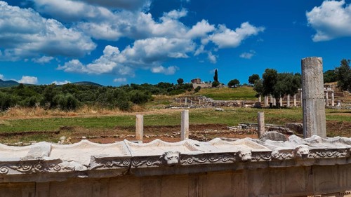 Temple of Messene, ancient ruined landscape with columns under blue sky in a natural setting,