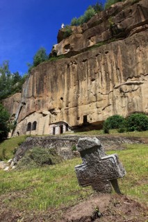 Corbii de Piatra rock monastery, stone ravens carved into a massive, 30-meter high sandstone wall,