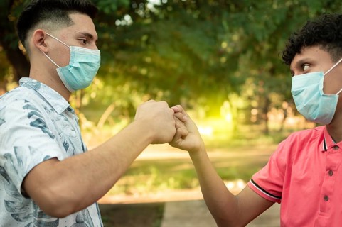 Two young men clashing their fists, image of two young men bumping their fists in a friendly way,