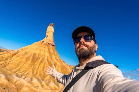 Tourist showing the castildetierra rock formation at bardenas reales natural park, navarre, spain,