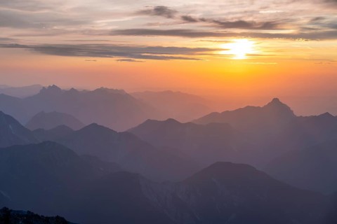 Silhouettes of mountains at sunset with sun, view from the summit of the Zugspitze, Wetterstein