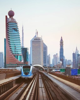 Dubai, UAE - 10th october, 2022: Driverless Dubai Metro train speeding along elevated tracks on