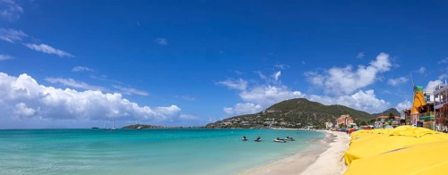 Wide panoramic view of the beach at Great Bay in Philipsburg Sint Maarten featuring numerous yellow