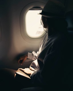Close up silhouette of caucasian woman looks out the window of an flying airplane. Passenger on the