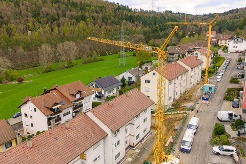 Aerial view of a residential area with active construction sites and green landscape, residential