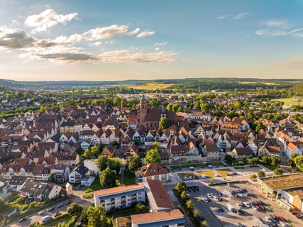 Aerial view of the city centre with dense buildings, churches and streets in a hilly landscape,