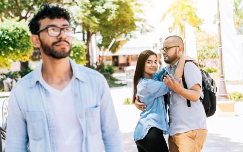 Distracted girlfriend looking at another man on the street. Unfaithful girlfriend looking at