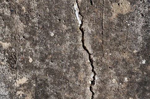 Old concrete wall with cracks, structures and green moss