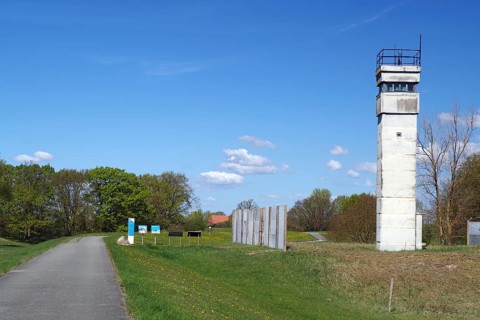 An old watchtower next to a road in a rural landscape, GDR border, Neu-Bleckede, spring, bicycle