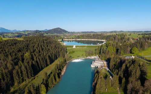 Aerial view of a river flowing through a wooded landscape with a country road, Lech barrage at