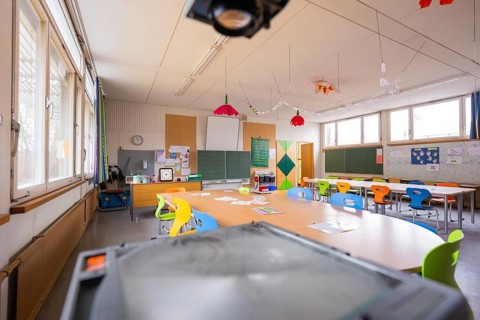 Bright, colorful classroom with tables, chairs and decorative elements, a quiet atmosphere,