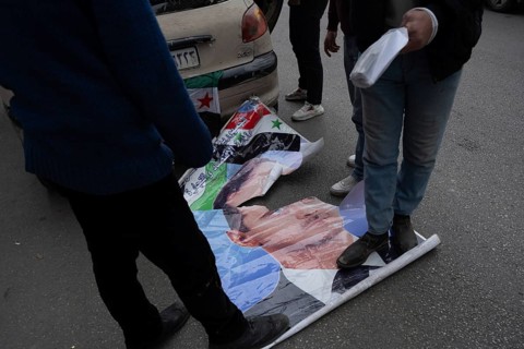 Damascus, Syria. December 8th 2025. Syrians stamp on a poster of the former Syrian president Bashar
