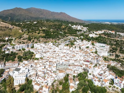 The brilliant White Town of Casares clings to a steep hillside. In the background the Sierra