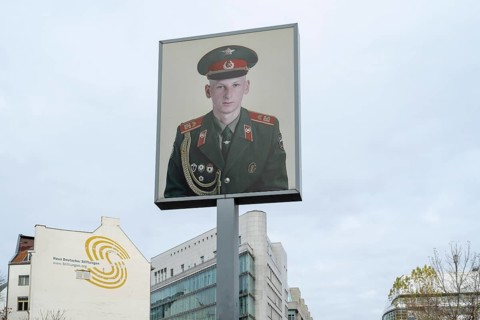 Sign with the portrait of a soldier, Checkpoint Charlie, Mitte, Berlin, Germany