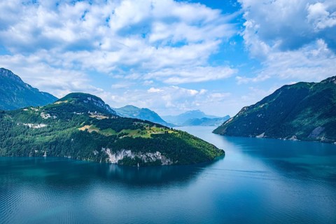 Idyllic mountain landscape with a calm lake under blue sky and clouds, Lake Lucerne, Brunnen,