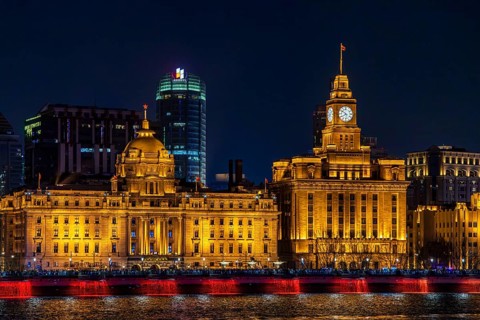The floodlit Bund heritage buildings including HSBC and Customs House reflected in the Huangpu