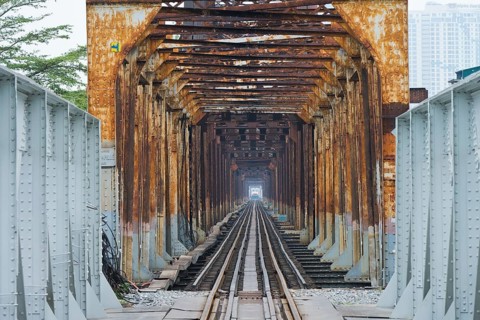 A train, locomotive, of the Vietnamese State Railways crosses the Long Bien railway bridge over the
