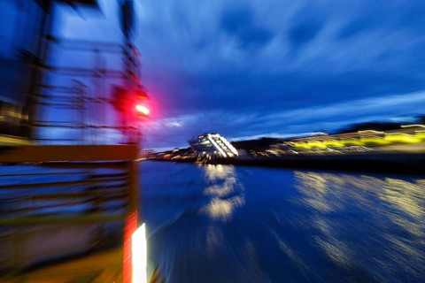 Red light signal on harbor ferry, view of illuminated Dockland office building, harbor tour at