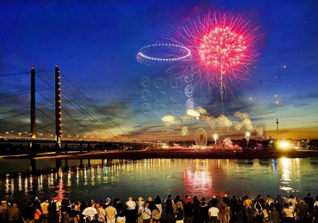 Rheinkirmes, many people watch the drone show and the colorful fireworks at night, Düsseldorf,