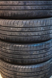 Close-up of four stacked black rubber automobile tires with deep grooves in home garage, Quebec,