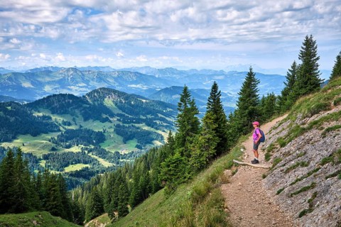 Active senior woman hiking along the picturesque ridge of the Nagelfluh Mountains in the Allgäu